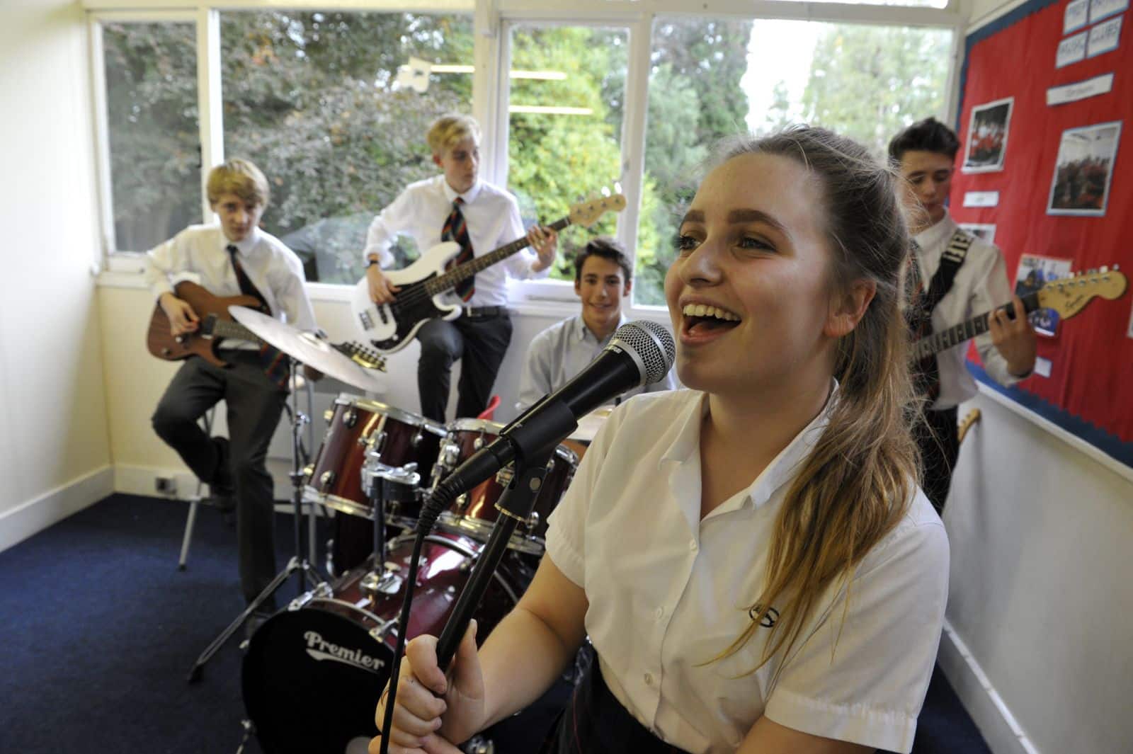 Female student singing with a band in the background